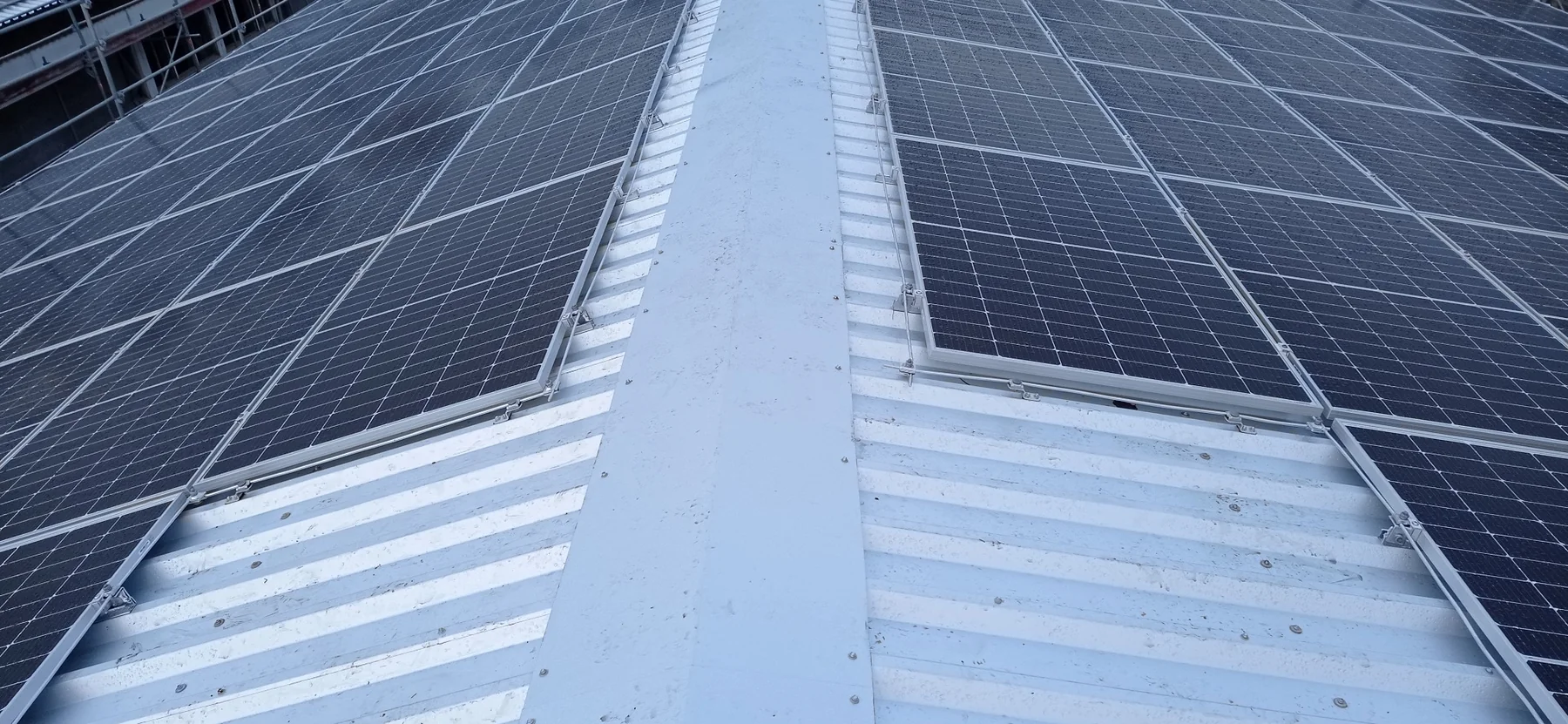Photovoltaic panels installed along an industrial roof ridge
